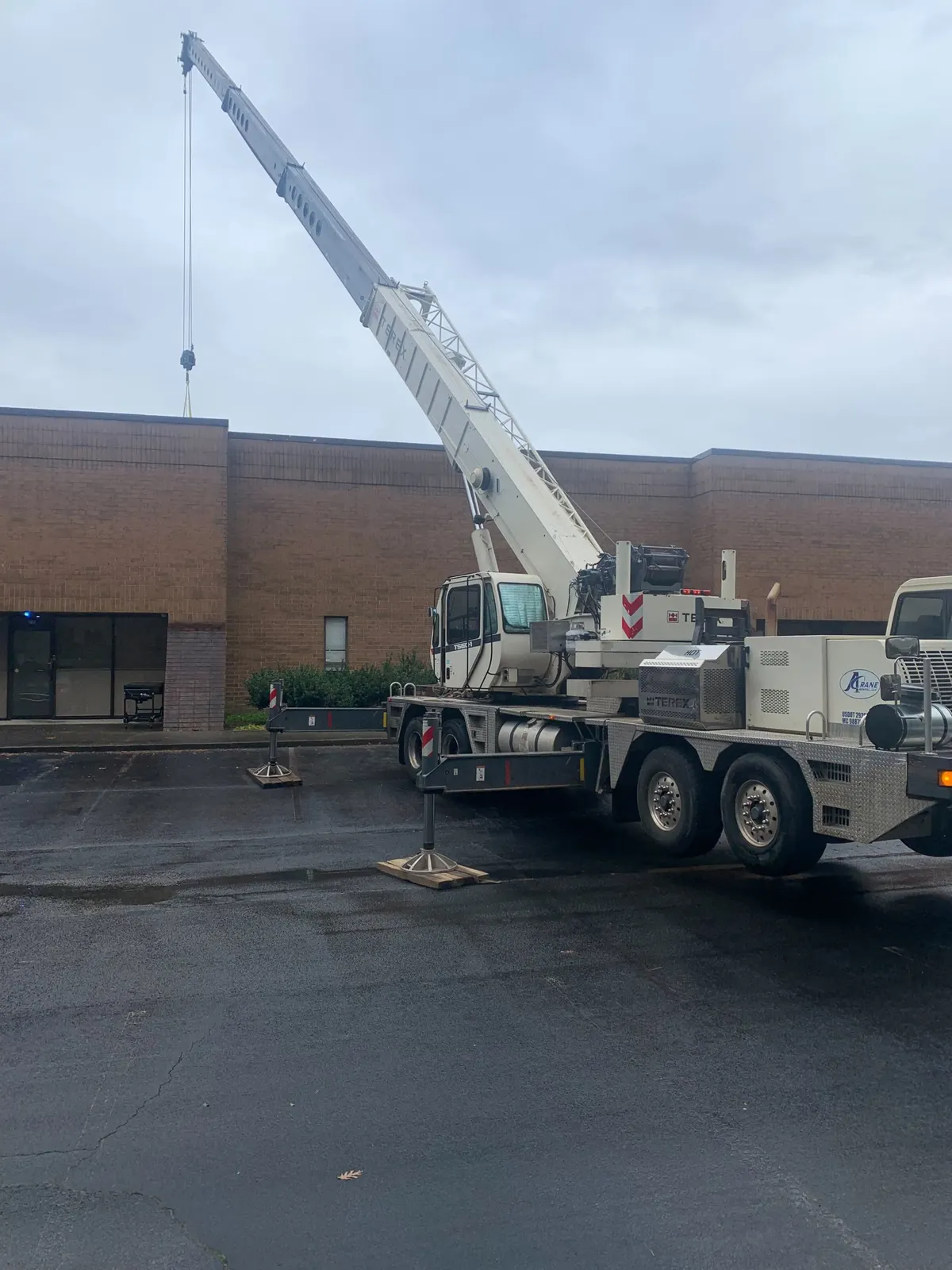 Crane lifting HVAC equipment onto a commercial rooftop
