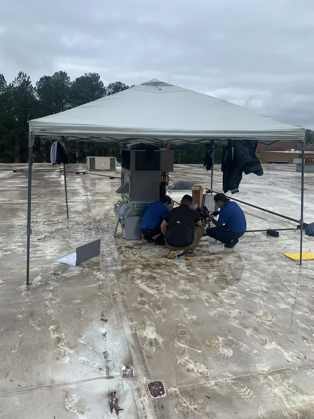 Rooftop HVAC work under a weather canopy