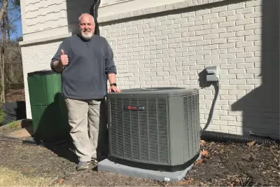 Technician beside a residential condenser installation