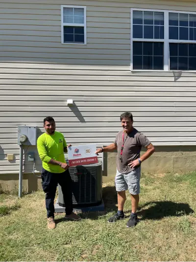 Technicians beside a dual outdoor condenser installation