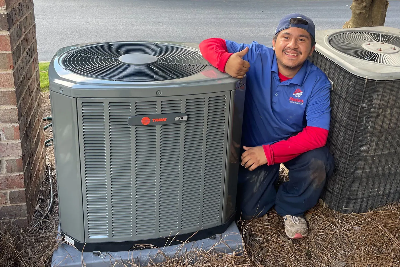 Staton technician with a newly installed Trane AC condenser